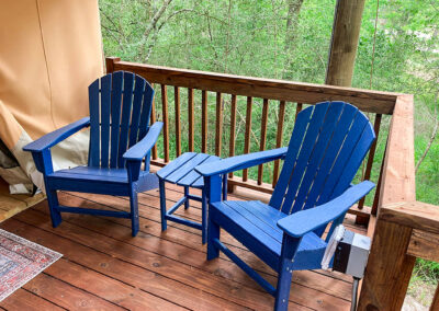 blue adirondack chairs on wooden deck forest view outdoor relaxation summer seating porch furniture