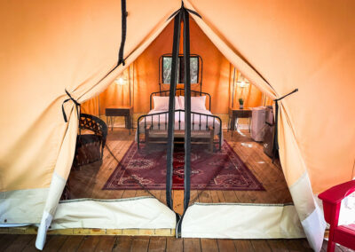 glamping tent interior with cozy bed stylish rug and rustic lamps highlighting luxury camping experience in nature