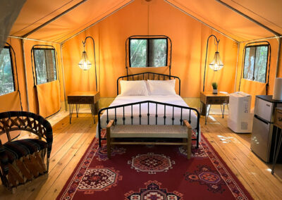 luxurious glamping tent interior cozy decor with bed vintage furniture and warm lighting in forest setting