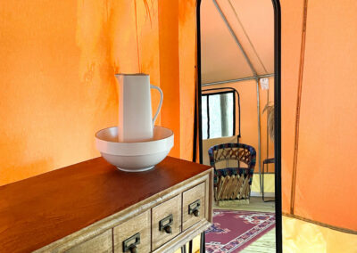 modern rustic interior with wooden console tall mirror pitcher and bowl in cozy tent