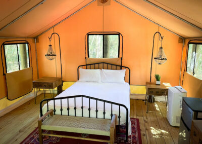 glamping tent interior with cozy bed rustic decor natural wood flooring and chic lighting enhancing outdoor luxury experience