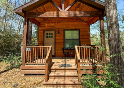 Charming wooden cabin surrounded by trees, rustic retreat, cozy nature escape, relaxing cabin getaway.