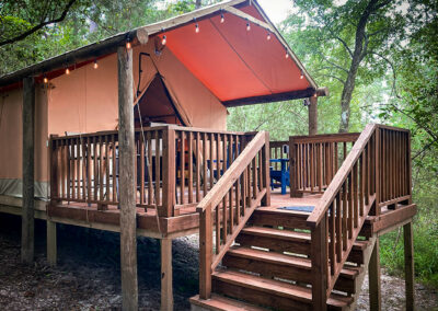 rustic glamping tent with wooden porch nestled in lush forest perfect for nature retreats and outdoor camping experiences