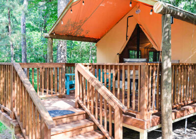 rustic glamping tent with wooden deck in forest setting ideal for nature retreats and outdoor getaways