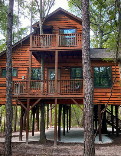 elevated wooden treehouse cabin surrounded by lush forest nature retreat eco friendly accommodation rustic architecture