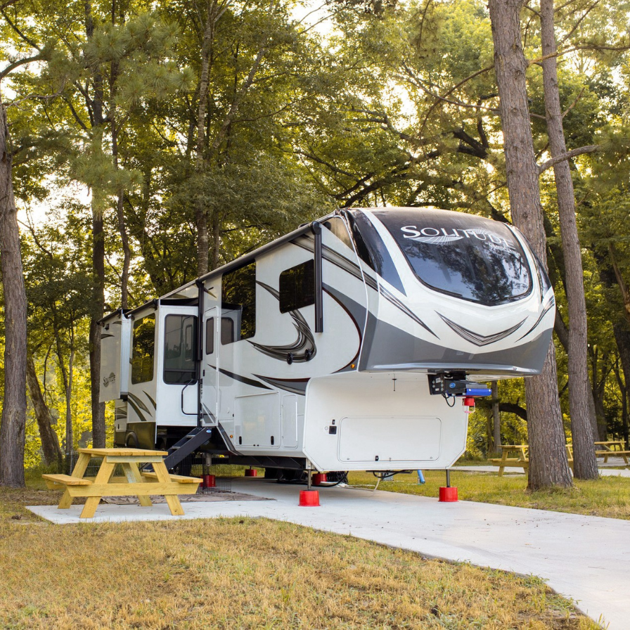 luxurious fifth wheel rv parked in forest campground with picnic table outdoor adventure camping getaway