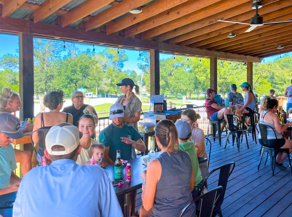 outdoor patio dining people socializing wooden deck summer day casual gathering friendly atmosphere leisure scene