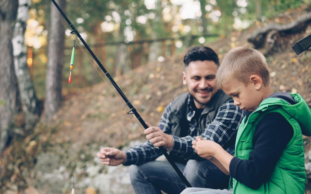 Father and son enjoying a fishing trip in nature, sharing quality time together.