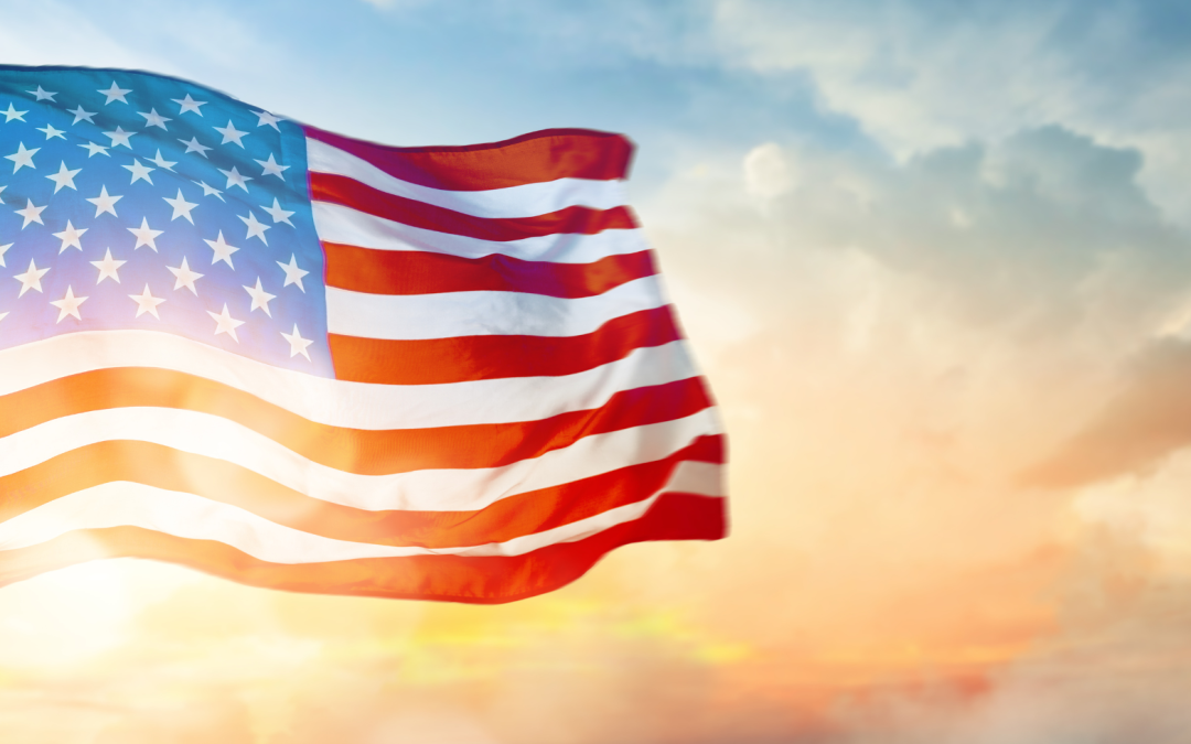 American flag waving against a vibrant sunset sky, symbolizing patriotism and freedom.