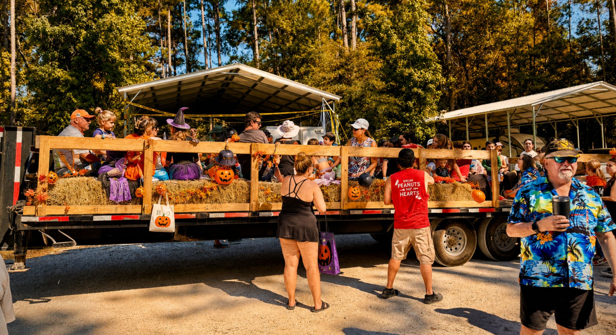 Halloween Festival Hayride at Two Creeks Crossing Resort Crowd of people in costumes on a hay-bale parade float decorated with pumpkins at a Halloween event