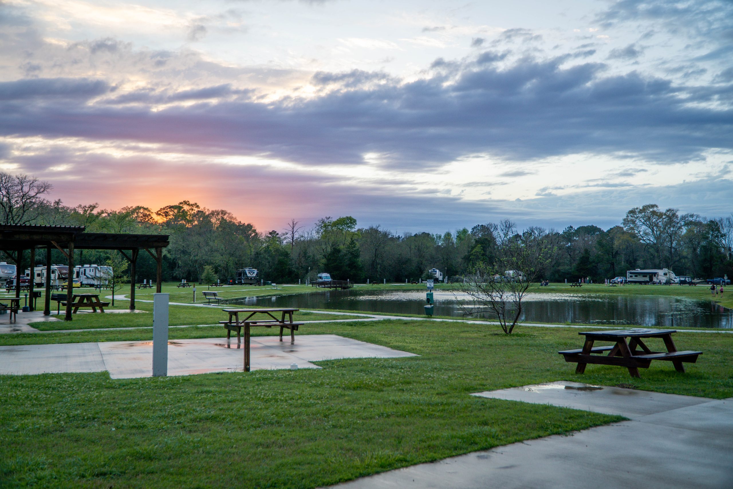 Concrete RV pad with a picnic table beside open grass at sunset Concrete RV pad with a picnic table beside open grass at sunset