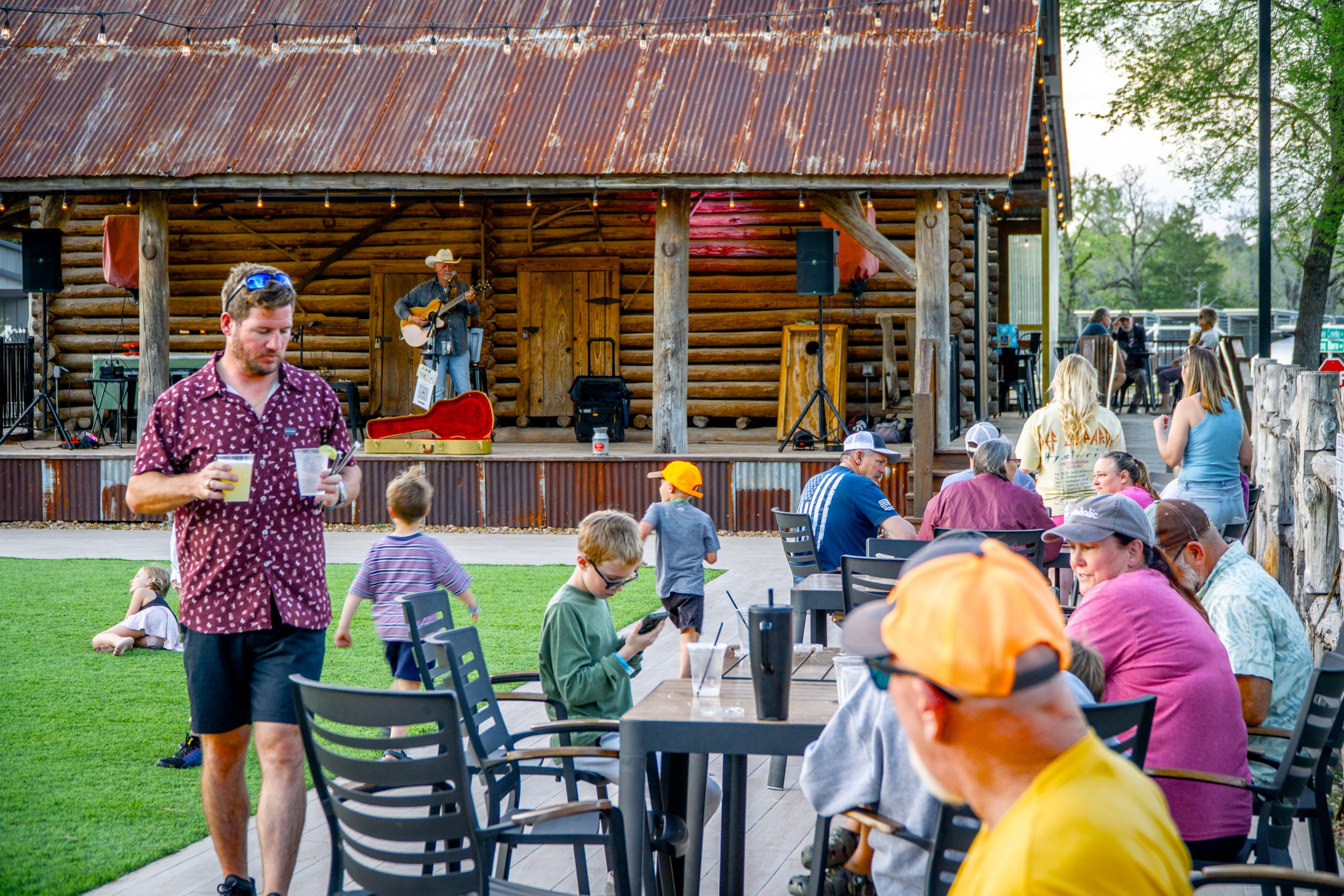Guests outdoors at Swampers Icehouse watching a live music performance