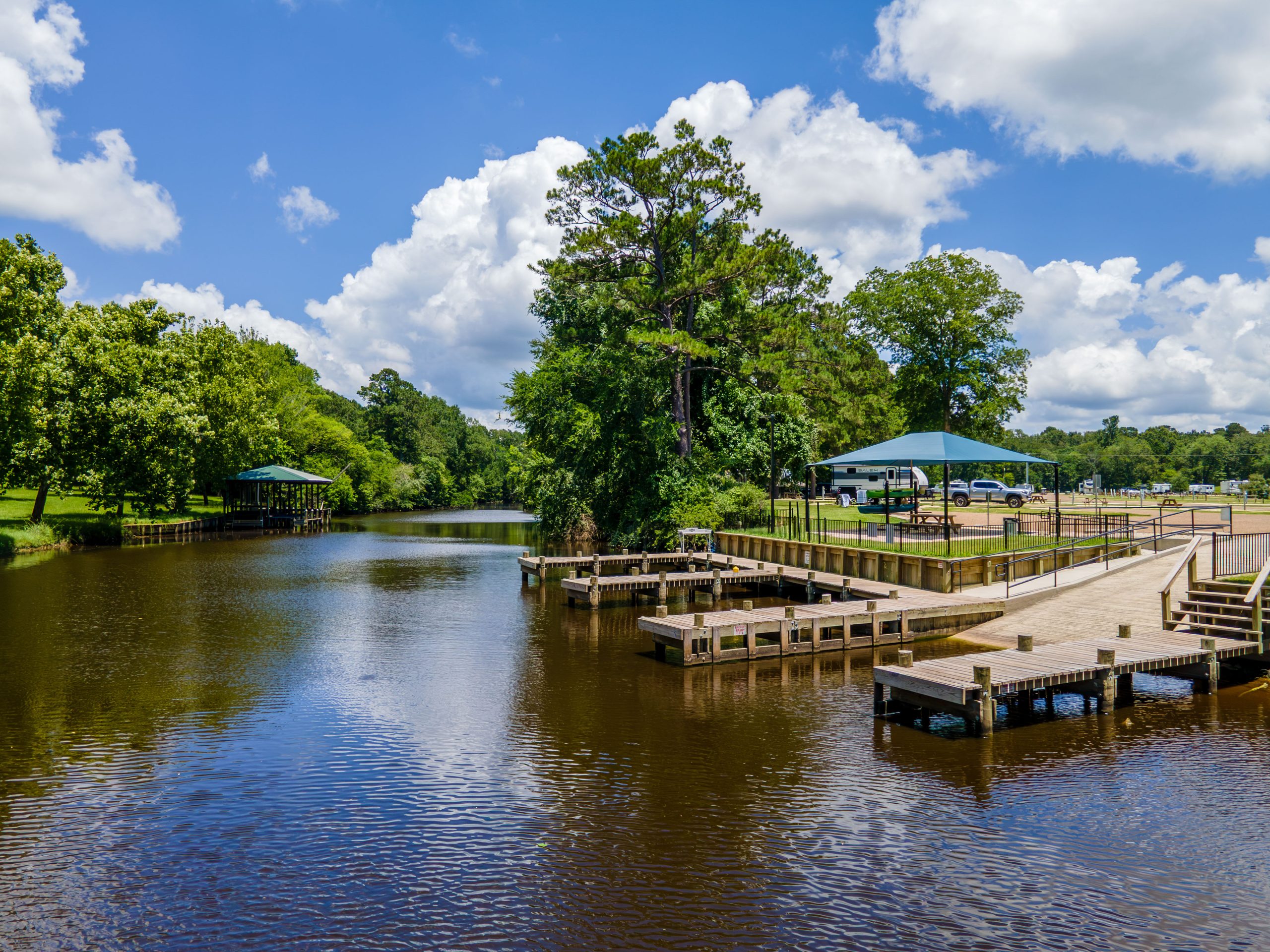 Wooden docks along a tree-lined creek at Two Creeks Crossing Resort Wooden docks along a tree-lined creek at Two Creeks Crossing Resort